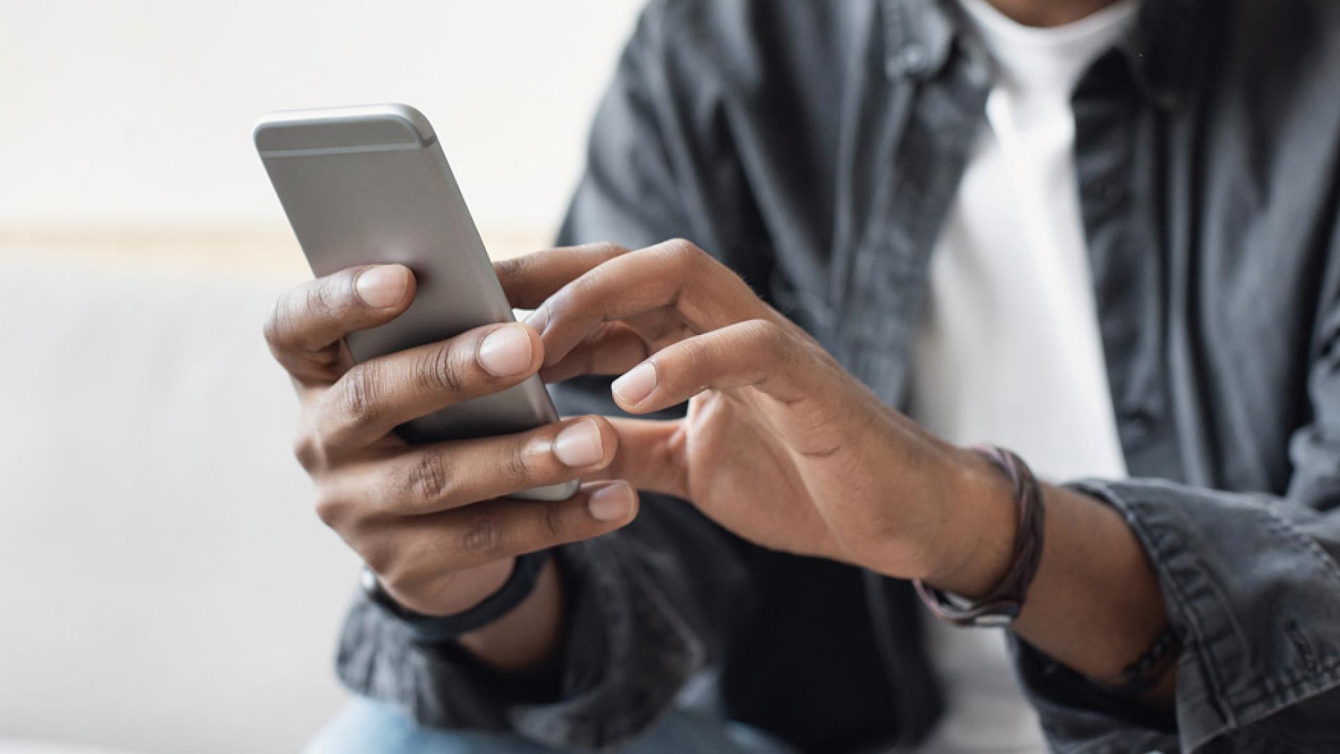 Man holding cell phone reviewing new website